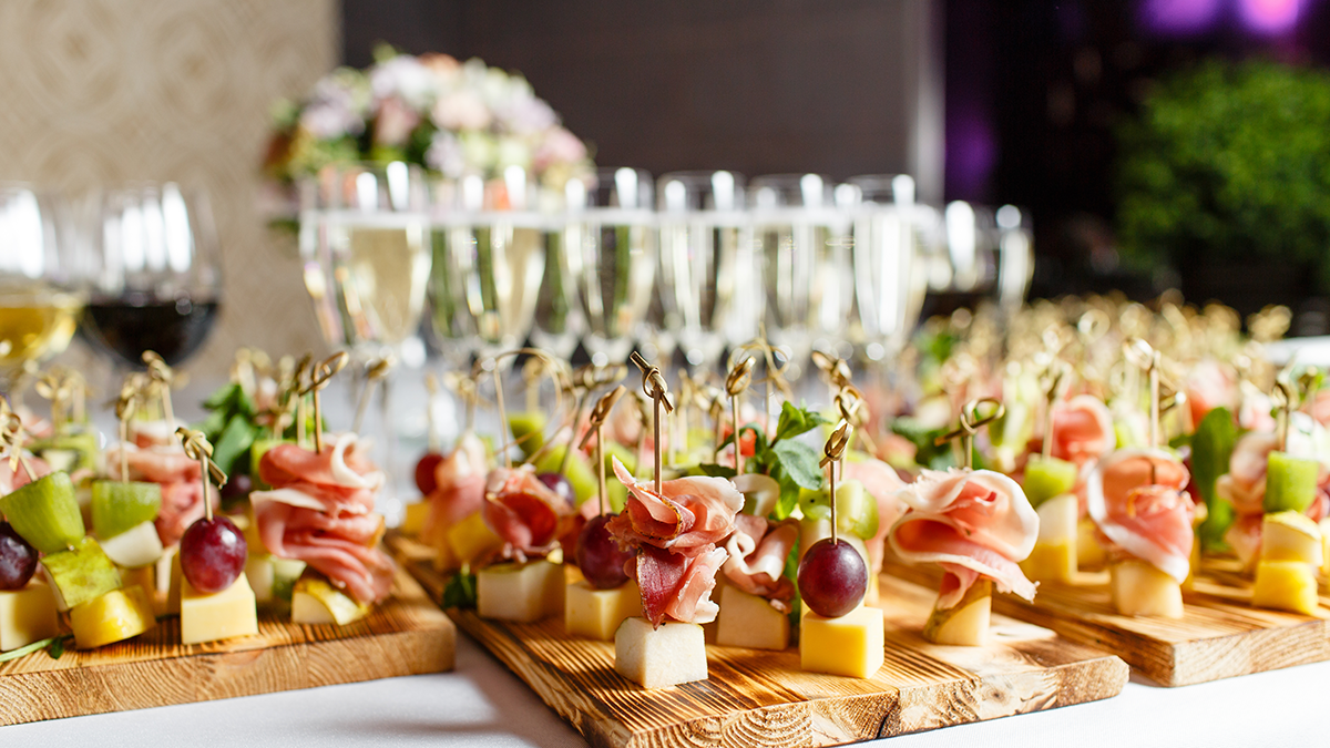 A catering table with Champagne, wine and finger foods