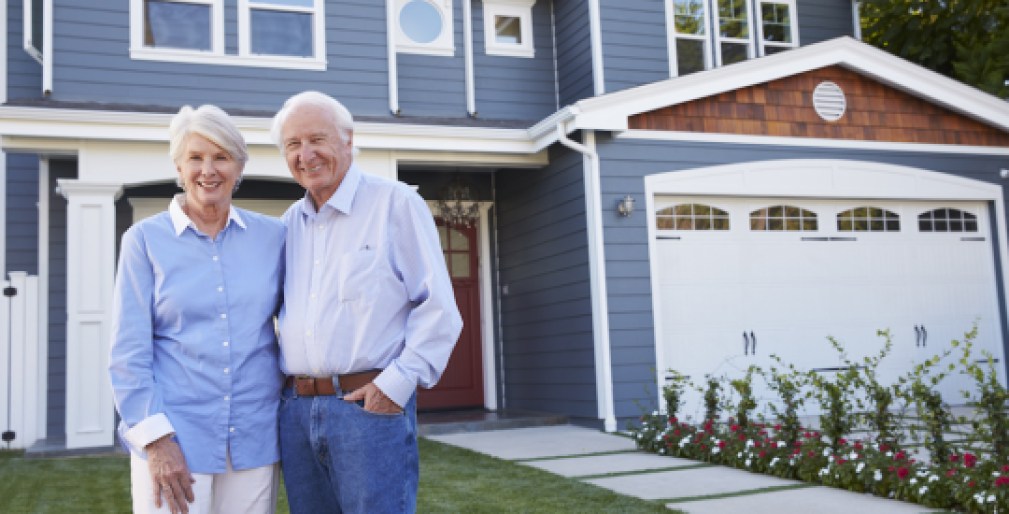 Portrait Of Senior Couple Standing Outside House