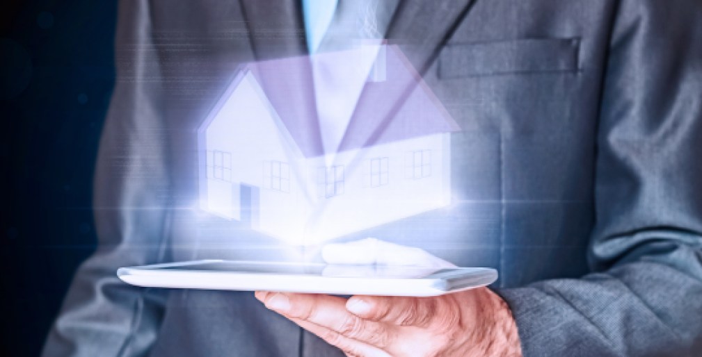 Businessman holding a virtual house. Virtual Holographic House. Business, mortgages and families concept