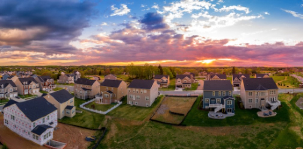 Aerial view of new construction street with luxury houses in a Maryland upper middle class neighborhood American real estate development in the USA with stunning sunset color sky