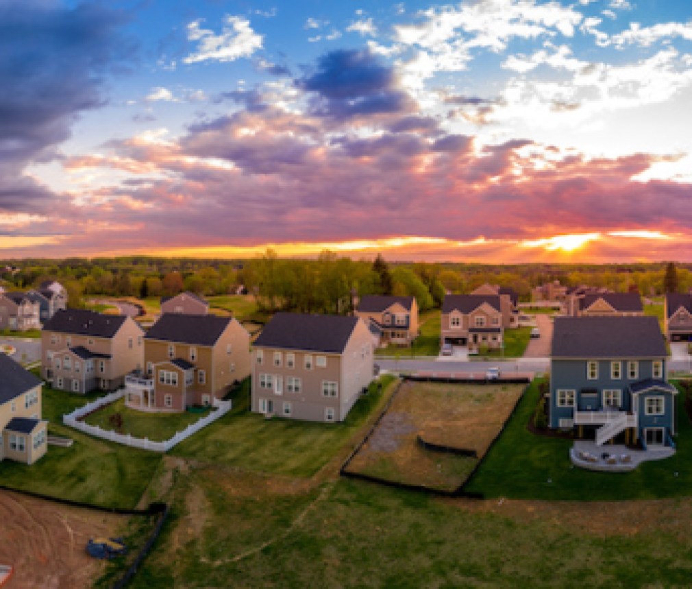 Aerial view of new construction street with luxury houses in a Maryland upper middle class neighborhood American real estate development in the USA with stunning sunset color sky