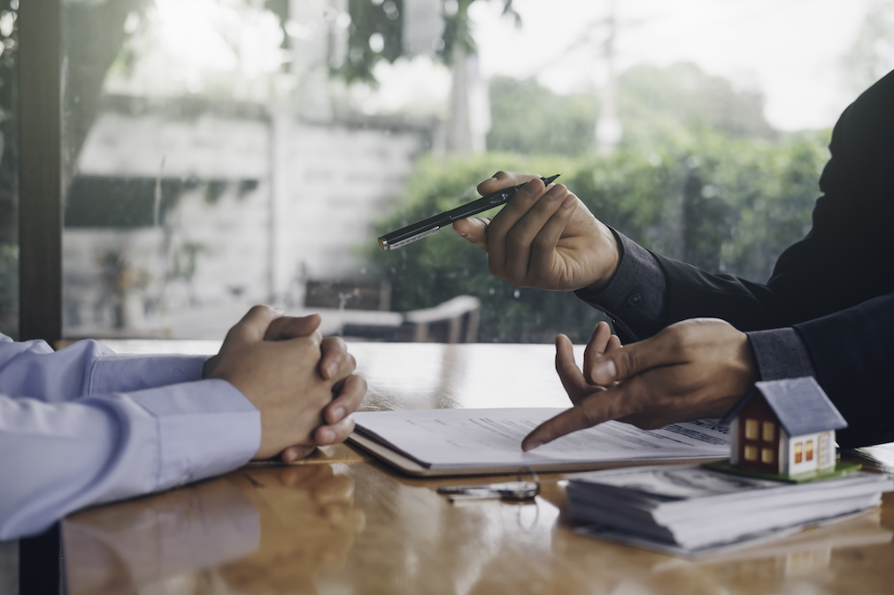 real estate agent holding house key to his client after signing contract,concept for real estate, moving home or renting property