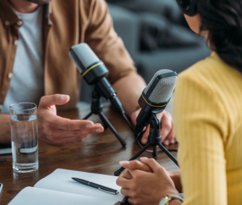 cropped view of two radio hosts recording podcast in broadcasting studio