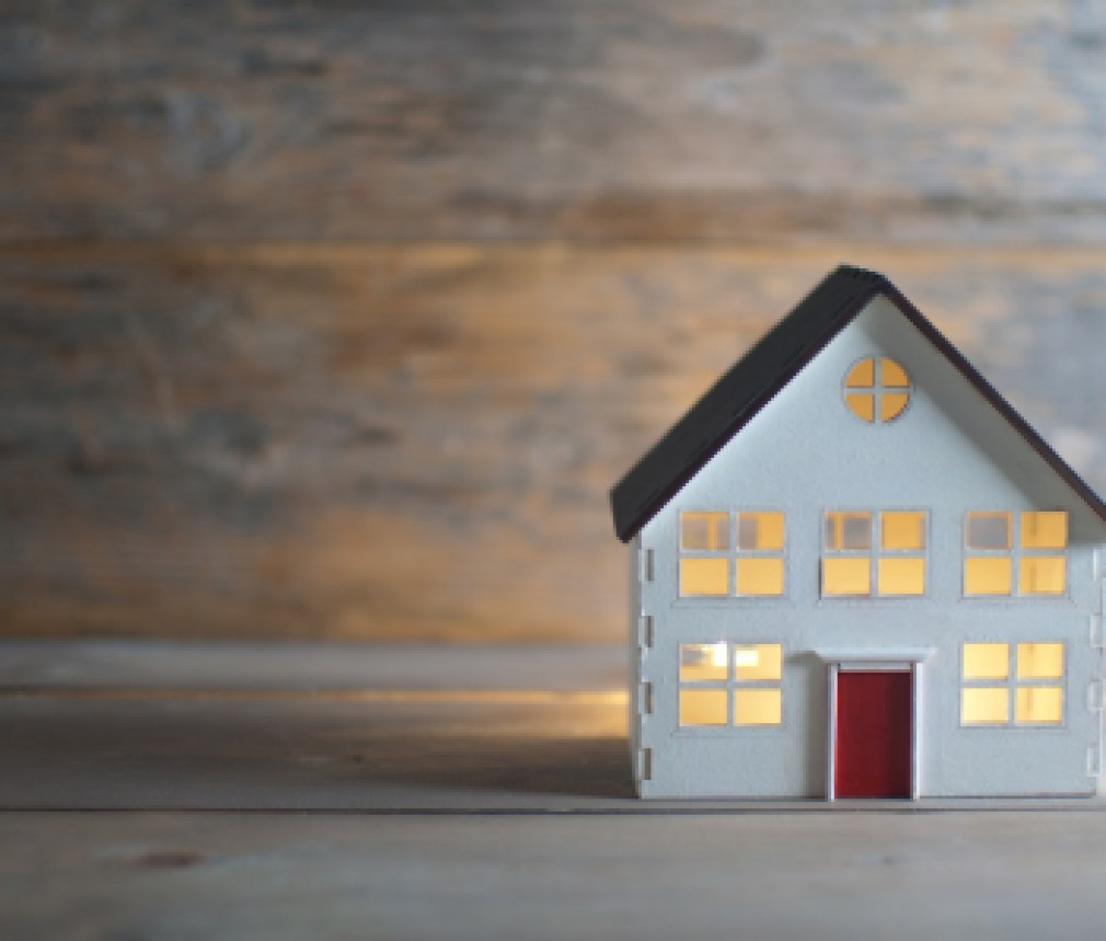 Miniature house over a wooden background