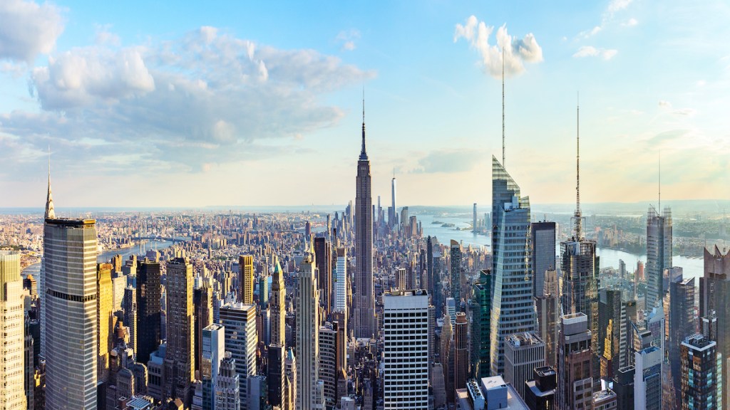 New York City skyline from roof top with urban skyscrapers before sunset.