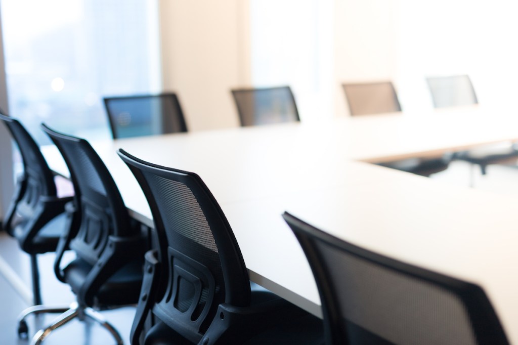 Modern meeting room with large windows, view back chair, outside building, city, tower view, soft focus.