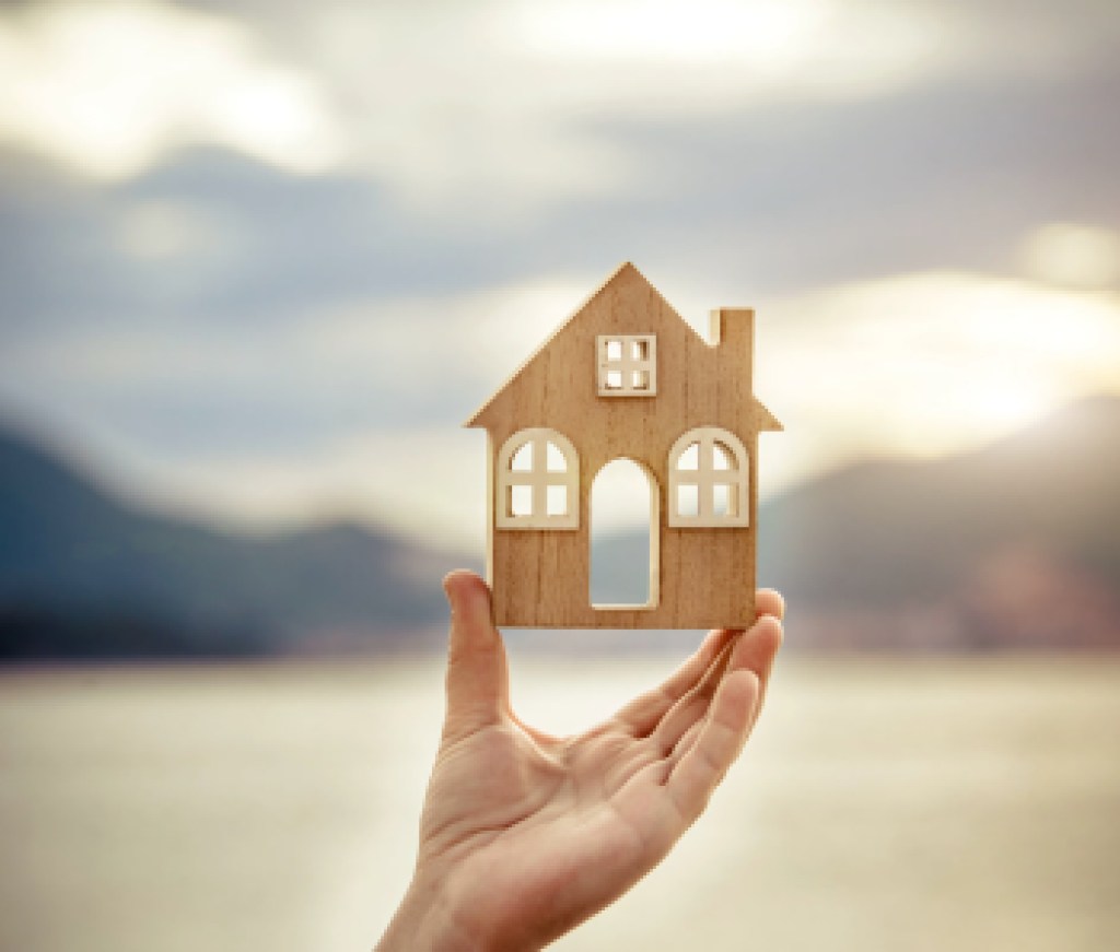 Girl holding the symbol of the house over the sea