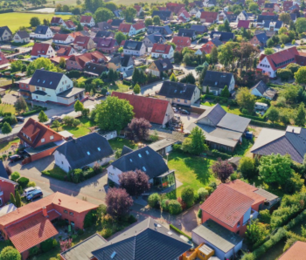 Aerial view of a suburb with detached houses, garden areas, lawns and a close neighbourhood