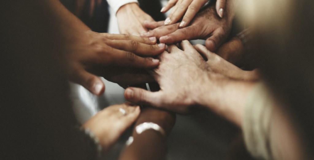 People with joined hands as a team