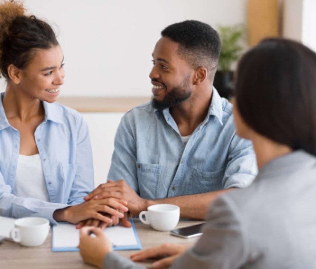 Smiling african american couple holding hands in financial advisor's office