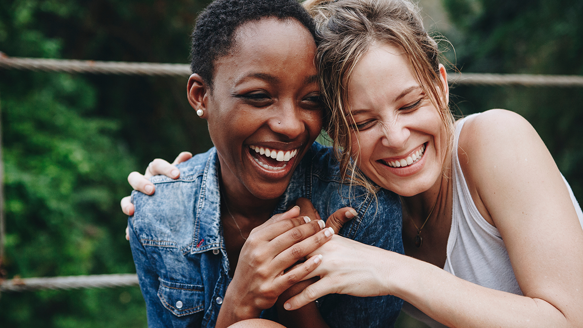 Two young women hugging and laughing